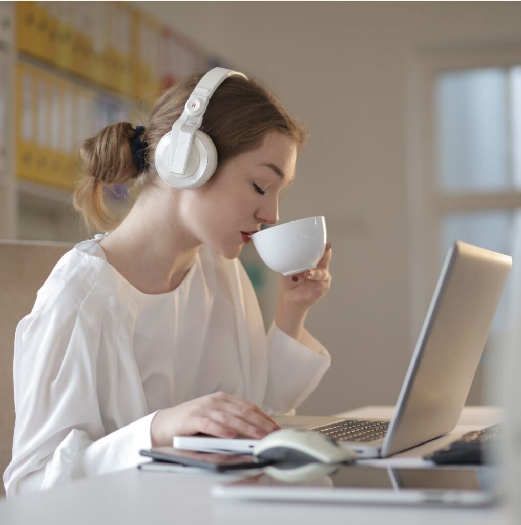 Studierende trinkt Kaffee bei einer Online Vorlesung