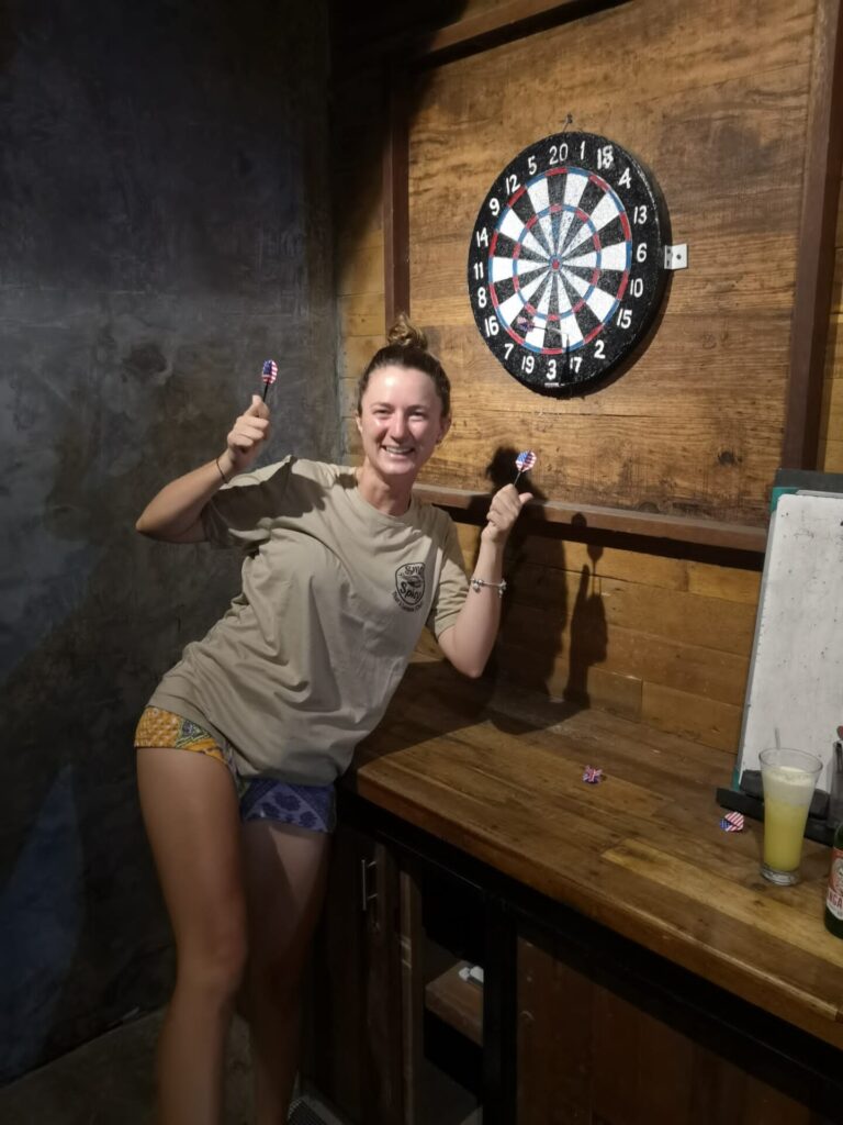 Eine junge Frau steht unter einer Dartscheibe