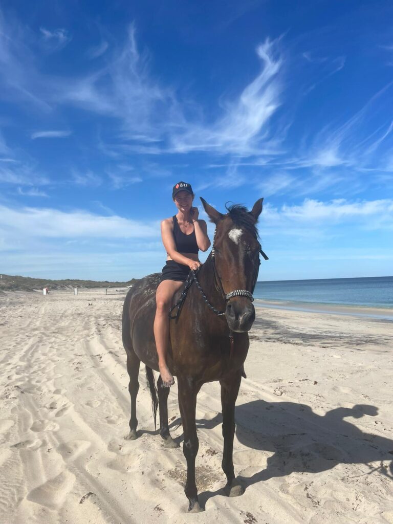 Eine junge Frau sitzt auf einem Pferd