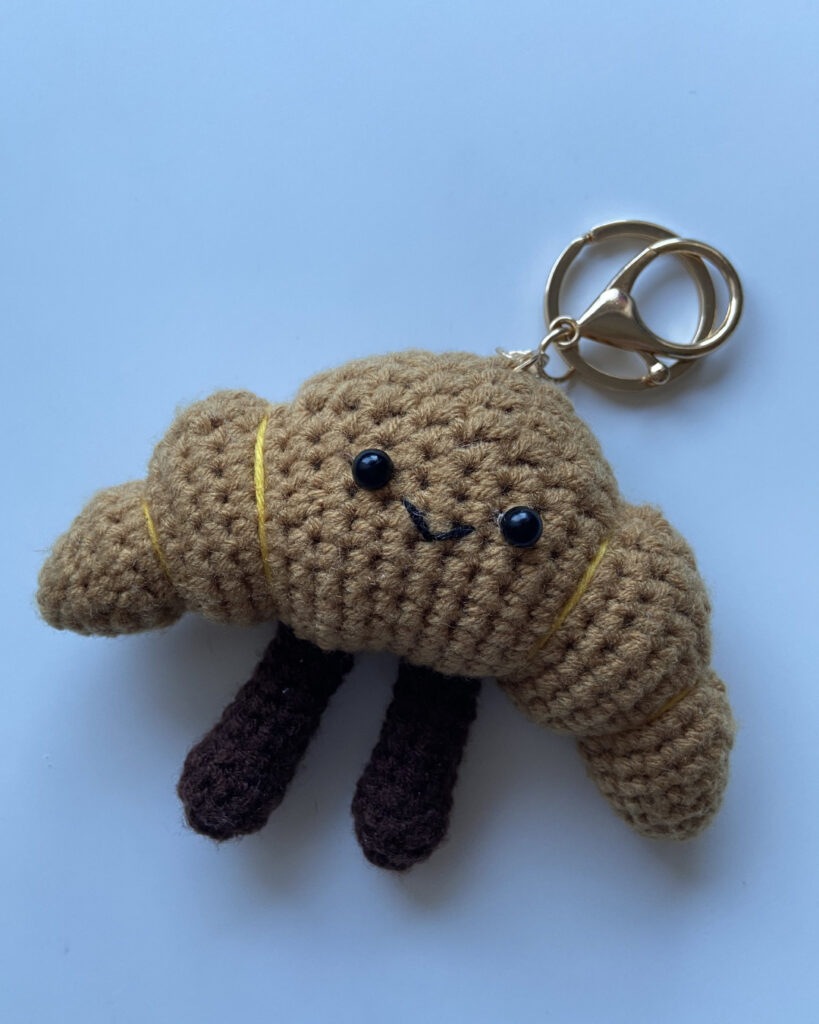 Gehäkeltes Croissant mit Anhänger und Gesicht (Amigurumi)