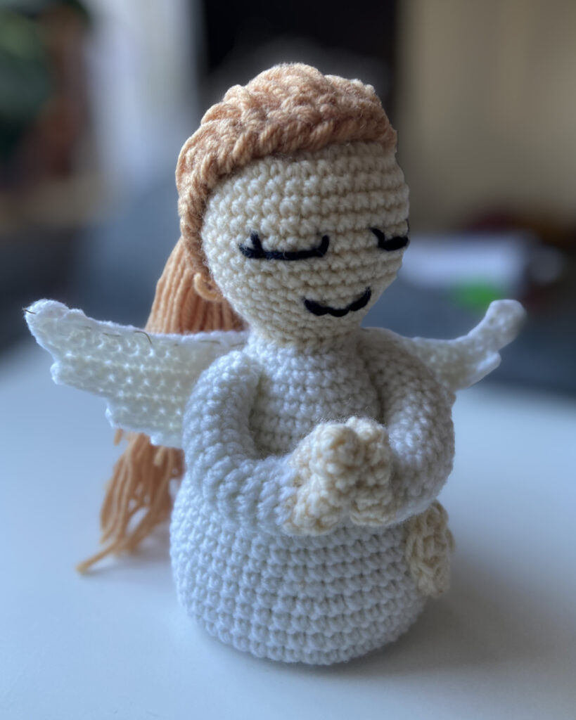 Ein Engel mit langen hellen Haaren.