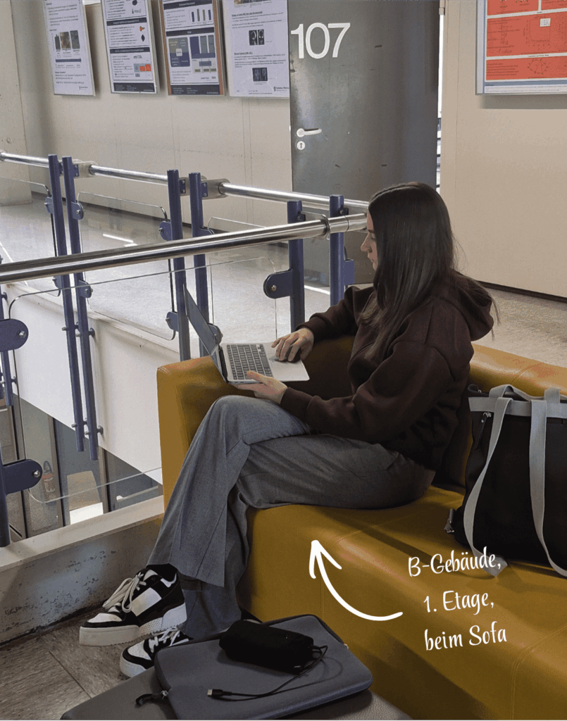 Marlene sitzt auf dem gelben Sofa mit Laptop im B-Gebäude